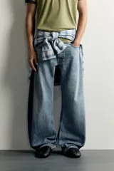 Jeans loose balloon fit de denim de algodón con diseño de cinco bolsillos y efecto lavado. Presentan bandas laterales en contraste y cierre frontal con cremallera y botón.