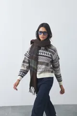 Sweater de punto con diseño jacquard de inspiración nórdica, cuello redondo y mangas largas. Presenta un patrón geométrico en tonos tierra, azul y blanco, con puños y ruedo acanalados.