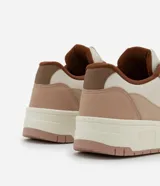 Championes de mujer marca Satinato confeccionados en PU con recortes contrastantes en tonos beige, crema y marrón. Poseen punta redonda, cierre por cordones blancos y suela de plataforma bicolor.