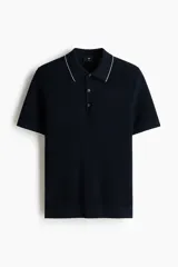 Remera polo azul marino en punto texturizado de mezcla de algodón, con cuello y bordes de mangas acanalados con ribete blanco, tapeta con tres botones y manga corta.