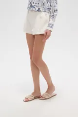 Short de viscosa color beige, con pinzas frontales, bolsillos laterales y cierre de botón.