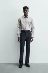 Camisa de manga larga para hombre, color gris claro con micro-estampado de cuadros sutiles. Presenta cuello italiano y cierre frontal de botonadura.