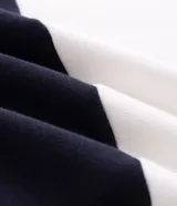 Buzo masculino confeccionado en algodón con felpa y diseño de bloques rayados en color azul marino y blanco. Presenta cuello polo, cierre frontal parcial con botones, manga larga y estampa frontal con íconos y texto.