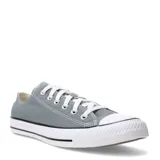 Championes urbanos Converse modelo Chuck Taylor All Star Ox, de corte bajo, confeccionados en lona color gris con puntera y suela de goma blanca.