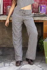 Pantalón de tiro alto, pierna ancha y recta, con cordón ajustable en la cintura. Presenta un estampado de cuadros vichy en blanco y negro.