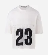 Remera de corte oversized confeccionada en tejido jacquard de color blanco con textura calada. Presenta mangas cortas, cuello redondo y un diseño gráfico deportivo con el número 23 en color negro en la parte frontal.