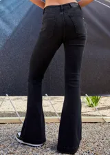 Jean de tiro medio-alto en color negro lavado, con corte oxford y botamanga ancha con tajo lateral. Presenta cierre frontal con cinco botones metálicos visibles.