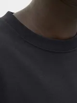 Remera de manga larga y cuello redondo con calce relajado. Presenta un diseño minimalista con un pequeño logo estampado en el centro del pecho.