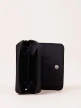 Billetera de nylon color verde esmeralda con cierre perimetral y parche de goma negro con logo grabado en el frente.