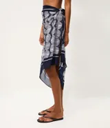 Pareo rectangular de playa en chiffon azul marino con estampado geométrico de lunares blancos, enmarcado por bordes y borlas en las esquinas.