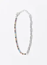 Pulsera de acero quirúrgico con una mitad de cadena de eslabones plateada y la otra mitad con piedras de zirconia de colores engarzadas.