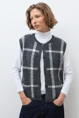 Chaleco de punto jacquard con diseño de cuadros, cuello redondo y cierre frontal con botones.