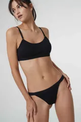 Bralette de algodón negro con escote redondo, breteles ajustables y banda elástica inferior. Diseño sin aros con copas removibles.
