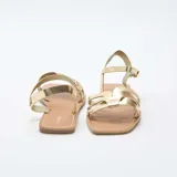 Sandalias planas color dorado, con múltiples tiras delanteras cruzadas y tira ajustable al tobillo con hebilla metálica.