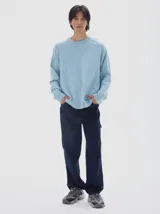 Buzo de punto color celeste, con cuello redondo y manga larga, de calce holgado y puños acanalados.