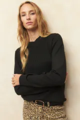 Polera negra de tejido acanalado, de manga larga y corte ajustado.