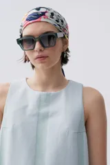 Vestido corto sin mangas de denim liviano a rayas verticales celestes y verdes. Cuenta con cuello redondo, abertura en la espalda y bajo desflecado.