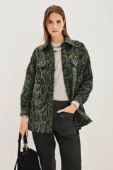 Tapado tipo sobrecamisa con estampado animal print, de corte recto y largo a la cadera. Presenta cuello camisero, cierre frontal con botones y dos bolsillos frontales con solapa.