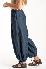 Pantalón tipo jean de corte wide leg y diseño balloon, con cintura elástica y cordones ajustables en los tobillos. Confeccionado en algodón denim de tono azul oscuro.