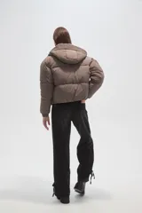 Campera puffer negra con capucha, manga larga, cierre frontal y cuello alto.