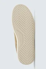 Zapatillas de cordones color beige, fabricadas en piel con acabado serraje. Presentan detalles de pespuntes en la parte superior y suela plana a contraste color crema.