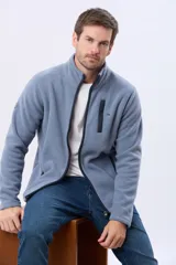 Campera polar de abrigo color celeste con cuello alto, cierre frontal y ribetes oscuros. Cuenta con bolsillos laterales y un bolsillo en el pecho con cierre y detalle en contraste.