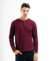 Remera tipo henley de manga larga confeccionada en tejido de algodón con textura mini piqué. Presenta un cierre frontal con tres botones y puños ajustados en las mangas.