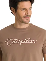 Remera de manga corta y cuello redondo color beige, con estampado del logo de la marca Caterpillar en el pecho.