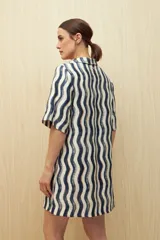 Vestido corto con estampado de líneas onduladas en blanco, negro y beige. Tiene cuello tipo solapa, escote en V y mangas 3/4.