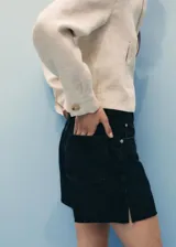 Short de denim negro de tiro medio, con diseño de cinco bolsillos, trabillas para cinto, cierre frontal con cremallera y botón, y bajo deshilachado.