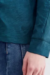 Remera de algodón peruano con textura jaspeada, de corte holgado y diseño de mangas largas con ajuste en la muñeca.