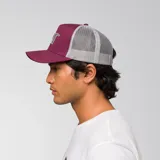 Gorra tipo trucker color bordó con malla trasera gris y logo de la marca bordado en el frente en color gris.