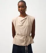 Blusa femenina color beige, sin mangas, con escote drapeado (degagê) y lazo ajustable en la cintura. Confeccionada en crepé de viscosa certificada.