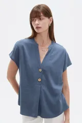 Blusa de viscosa color azul, de corte holgado, con mangas cortas, cuello en V y cierre frontal parcial con botones de madera.