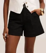 Short de mujer de sarga color beige claro, tiro alto, con pespunte contrastante en color blanco o crema. Presenta un corte regular y bolsillos delanteros y traseros.