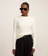 Blusa de manga larga de tricot color blanco, con textura geométrica en relieve, hombreras y cuello redondo, de la marca Cortelle.