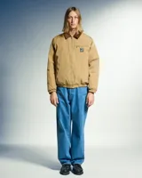 Campera color marrón claro con cuello de pana marrón, cierre frontal con cremallera, dos bolsillos laterales y un bolsillo pequeño con cremallera en el pecho.