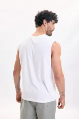 Musculosa blanca de corte clásico, sin mangas, con pequeño parche bordado en el pecho con la inscripción 'Good Wave' y una ola.