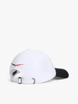 Gorra de béisbol de seis paneles confeccionada en algodón, con visera en contraste color negro y detalle de ribete tricolor. Presenta bordado frontal con el logo de Cadillac en fuente script, seguido de la inscripción Formula 1 Team y el logo de Tommy Hilfiger.
