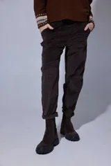 Pantalón de corte recto y tiro medio, confeccionado en tejido con patrón de cuadros oscuros. Presenta bolsillos frontales amplios y terminación con dobladillo en los tobillos.