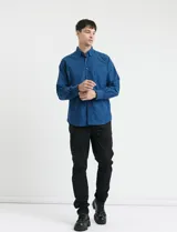 Camisa de manga larga con cuello button-down, cierre frontal con botones y bolsillo parche en el pecho. Presenta un diseño de textura sutil en color azul.