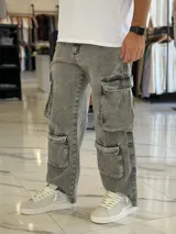 Pantalón de jean estilo cargo, color azul, de corte ancho y holgado, con múltiples bolsillos laterales en muslos y pantorrillas.