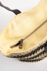 Bolso tipo tote de diseño trenzado con patrón de rayas en tonos marrones y beige, doble asa larga de material sintético oscuro y placa metálica con logo.