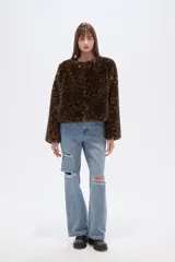 Chaqueta corta de piel sintética con estampado animal (leopardo/jaguar) en tonos marrones y negros. Tiene cuello redondo y corte holgado.