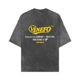 Remera de corte oversize con efecto acid wash en color gris oscuro. Presenta estampado gráfico en color amarillo en el frente con el logo de la marca y detalles de texto.