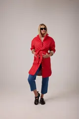 Campera roja capitoneada de nylon con forro de algodón, ruedo curvo, largo midi, cinta para atar a la cintura y bolsillos delanteros.