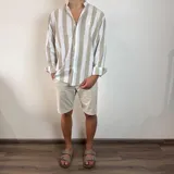 Camisa celeste y blanca a rayas verticales, de lino, con cuello mao y mangas largas con puños.