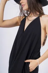 Vestido largo negro con escote en V, breteles finos y falda amplia con volado en el ruedo.