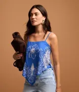 Blusa azul con estampa floral tropical blanca, escote recto y breteles finos ajustables.