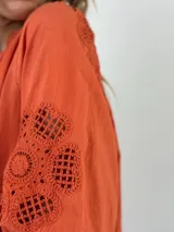 Blusa blanca de algodón con cuello mao y mangas 3/4 con detalles de encaje calado.